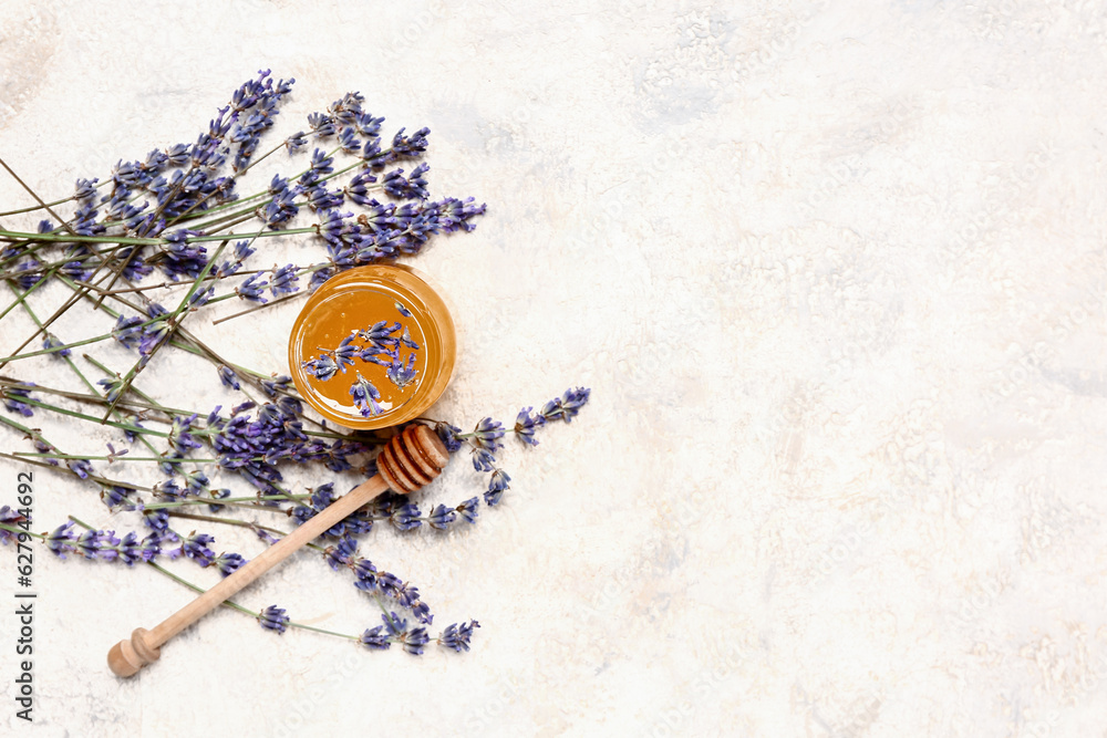 Jar of sweet lavender honey, dipper and flowers on white background