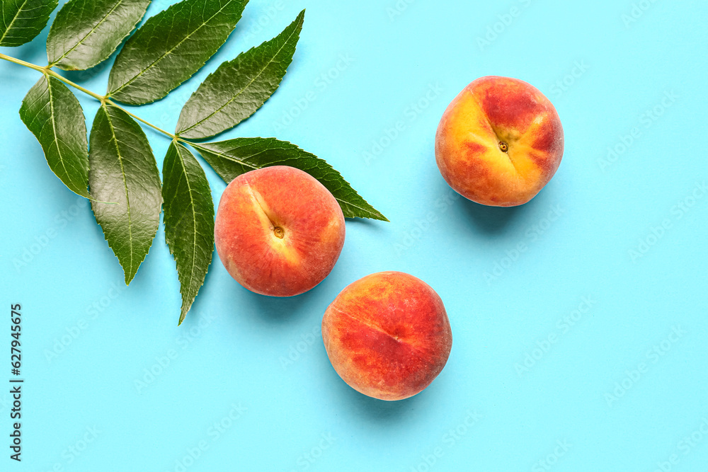 Sweet peaches and leaves on blue background