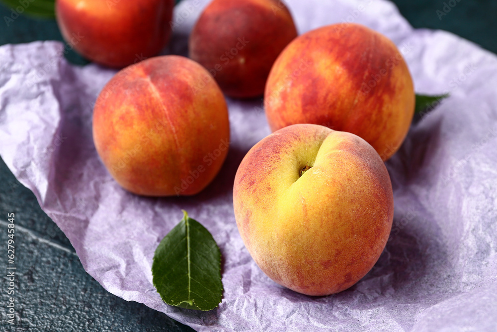 Baking paper with sweet peaches on dark background