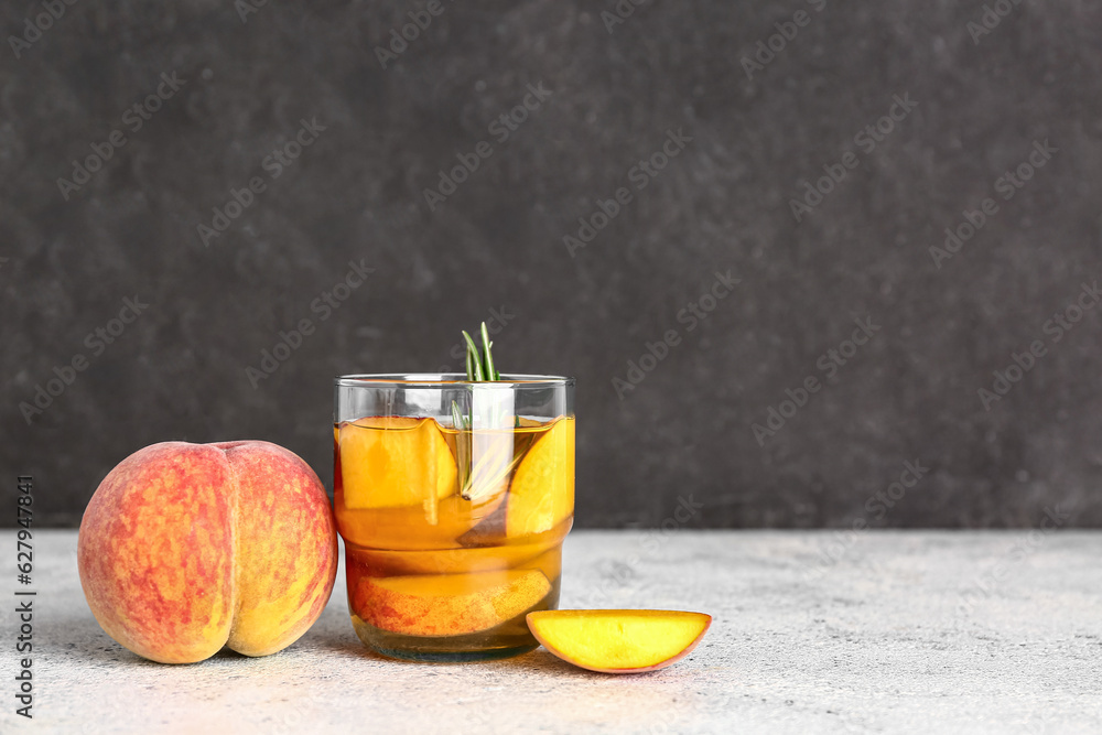 Glass of fresh peach lemonade with rosemary on white table