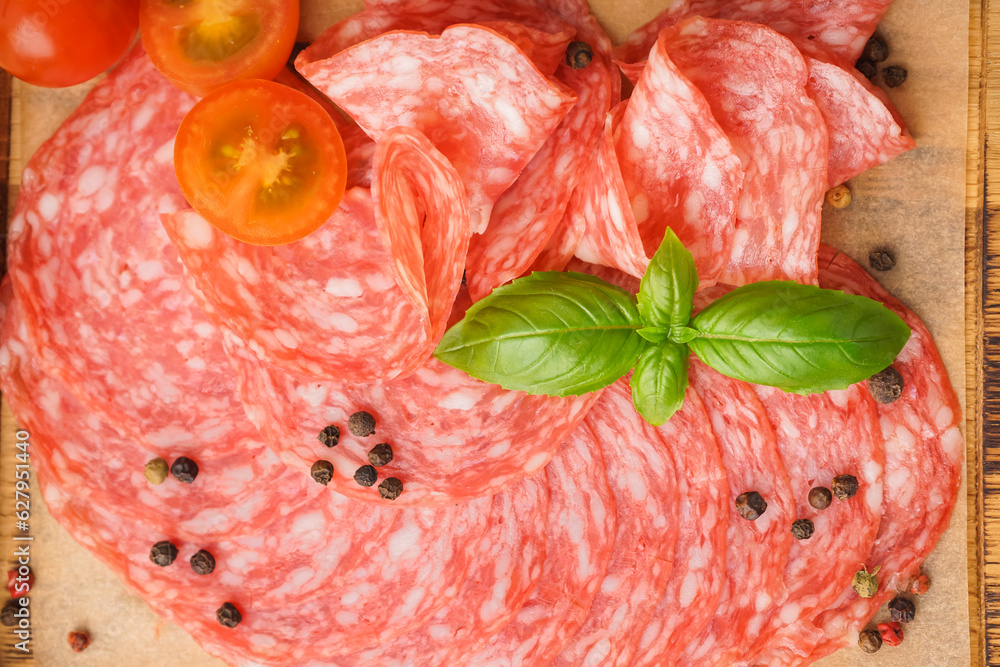 Slices of tasty salami on table