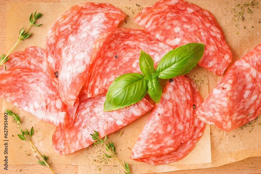 Slices of tasty salami on table