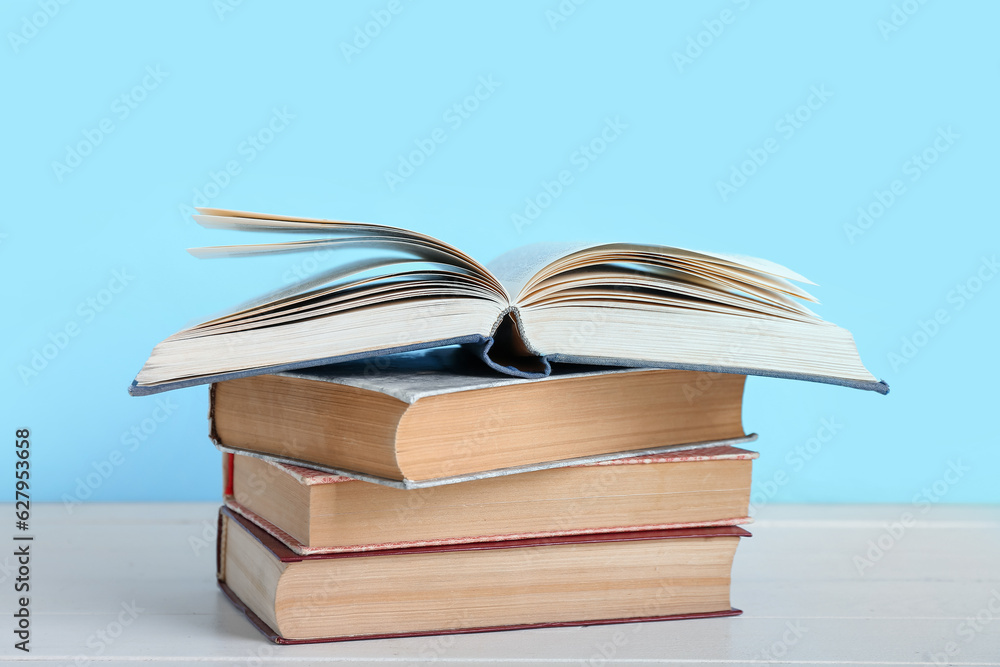 Stack of books on table against blue background