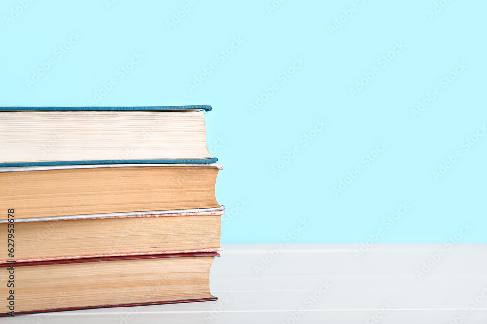 Stack of books on table against blue background