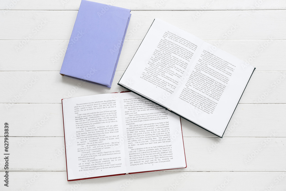 Open books on white wooden table