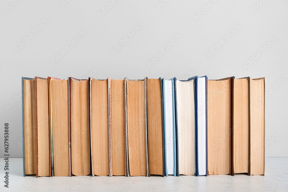 Row of books on table against grey background