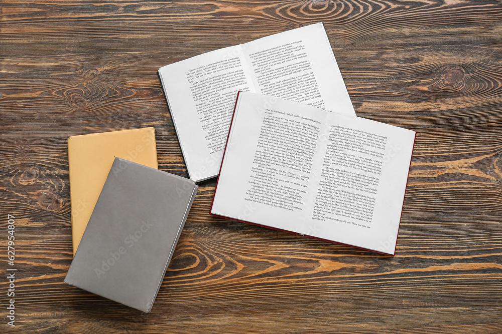 Open and closed books on wooden table