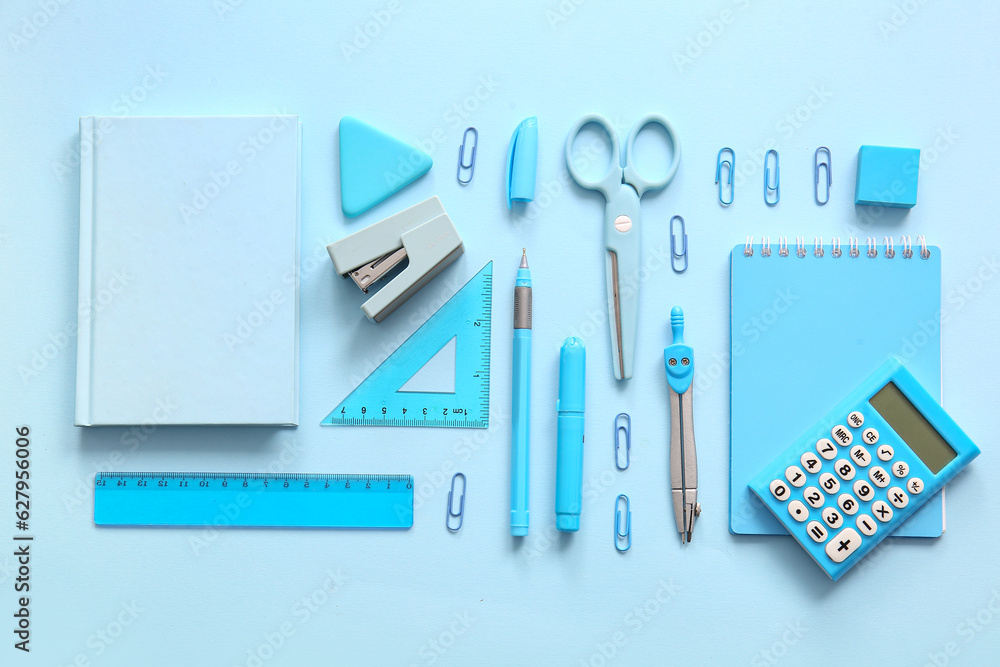 Different school stationery and notebooks on blue background