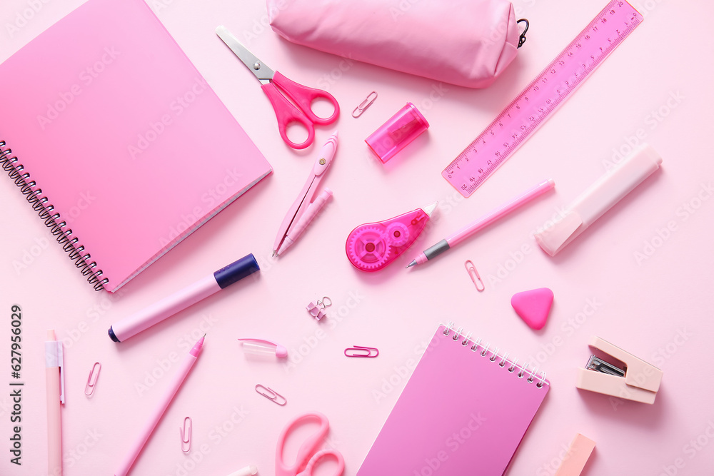 Different school stationery and notebooks on pink background