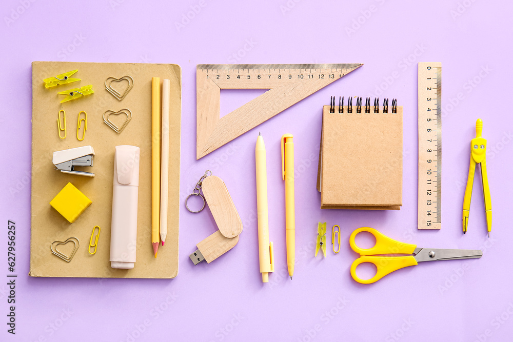 Notebooks and school stationery on purple background