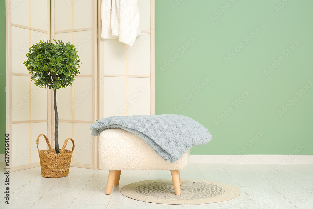 Pouf with cozy blanket in living room