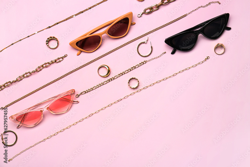 Stylish sunglasses with beautiful jewellery on pink background