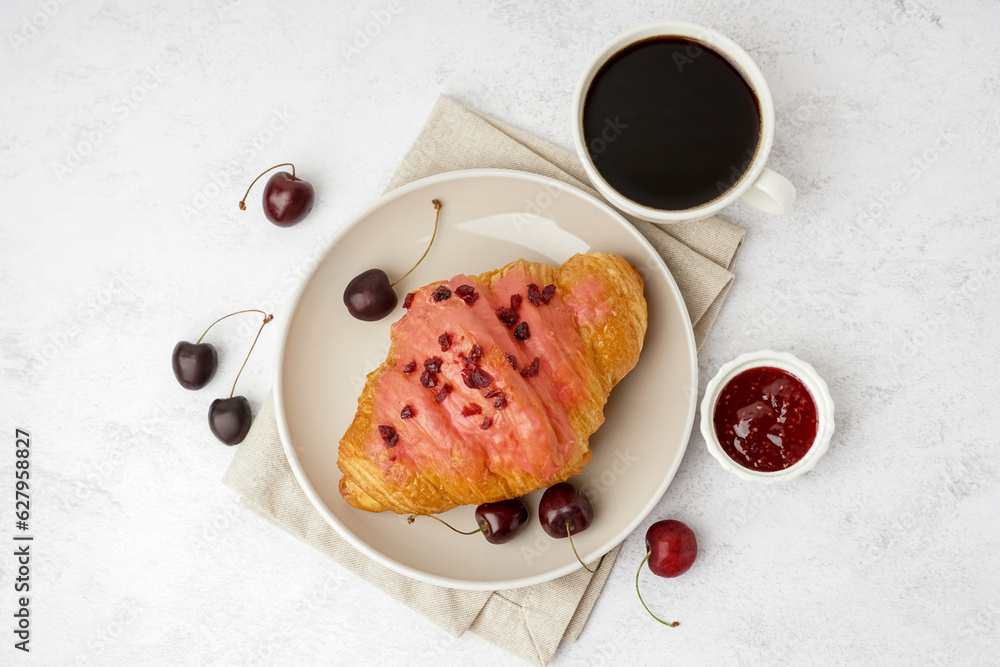 Plate with sweet croissant, cherries and cup of coffee on white background