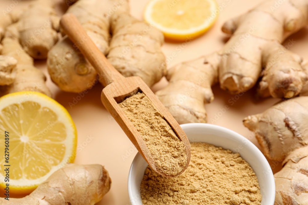 Fresh ginger roots, bowl and wooden scoop with dried powder on orange background