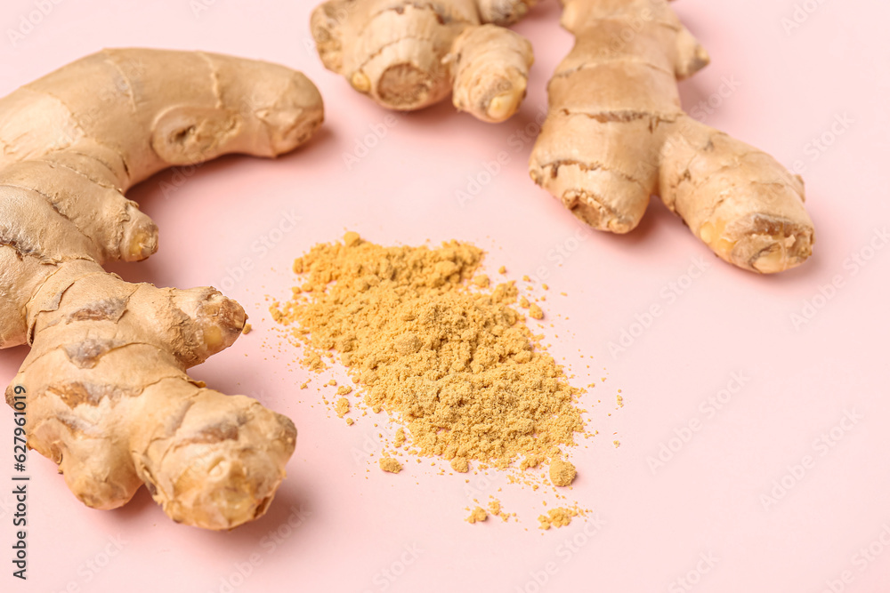 Fresh ginger roots and dried powder on pink background