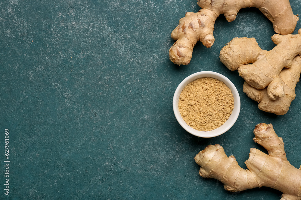 Fresh ginger roots and bowl with dried powder on blue background