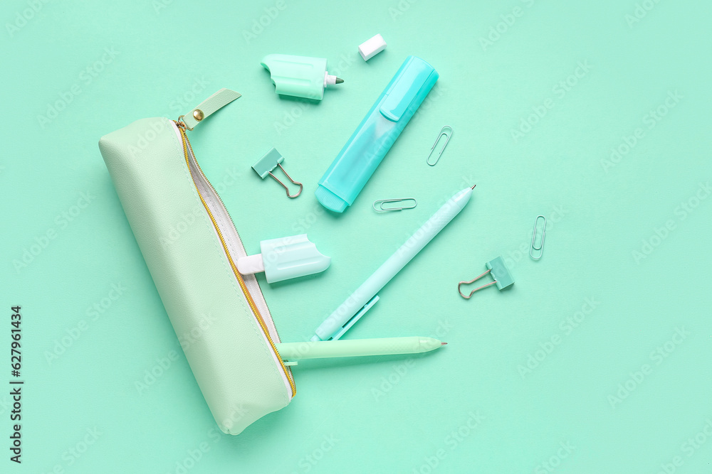 Pencil case with different stationery on turquoise background