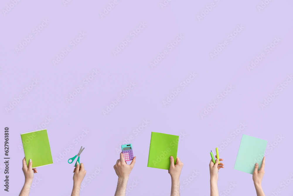 Hands with school supplies on lilac background