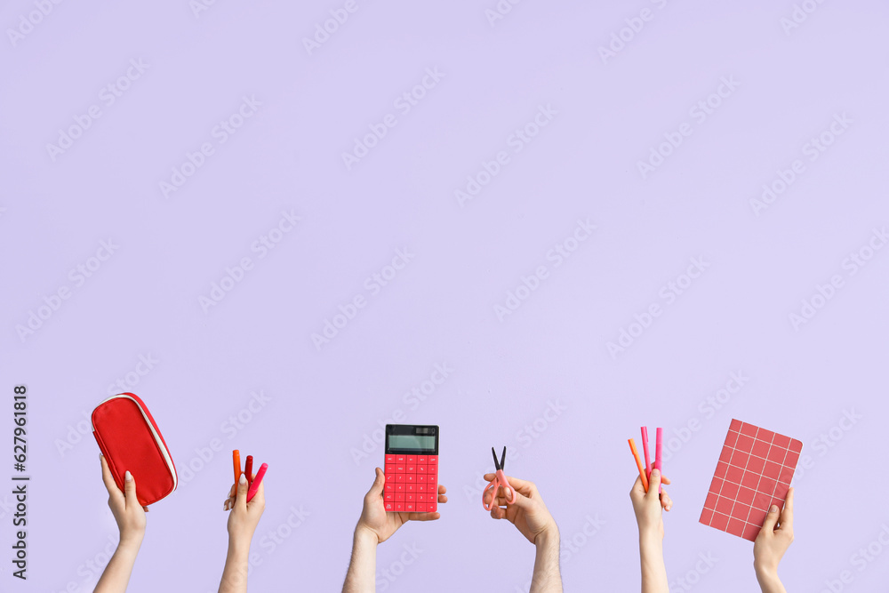 Hands with school supplies on lilac background