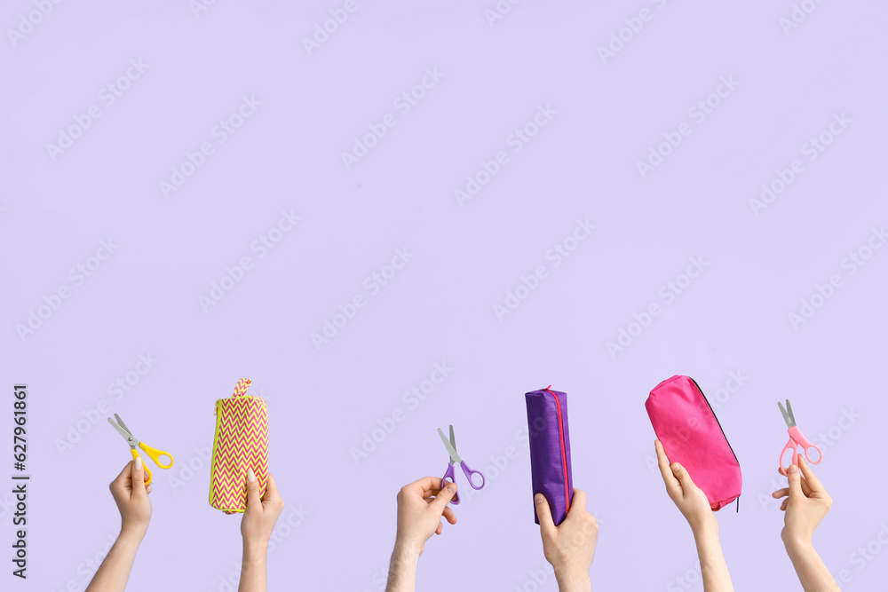 Hands with school supplies on lilac background