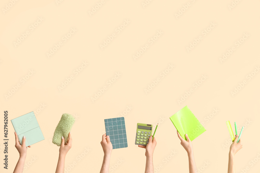 Hands with school supplies on beige background