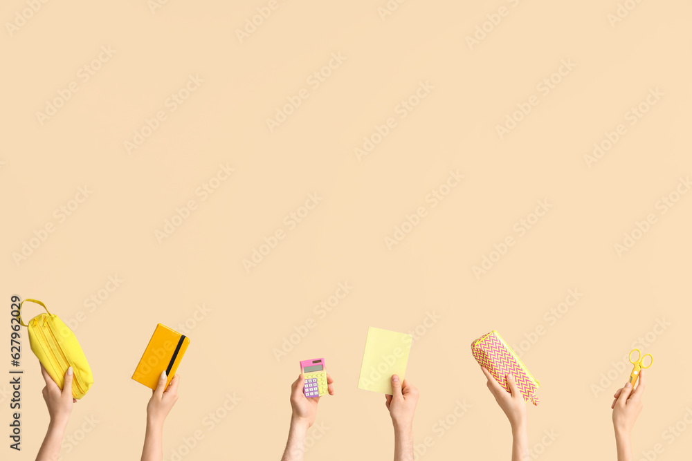 Hands with school supplies on beige background