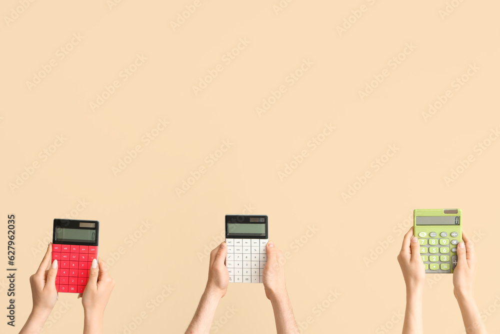 Hands with calculators on beige background