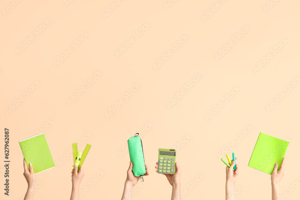 Hands with school supplies on beige background