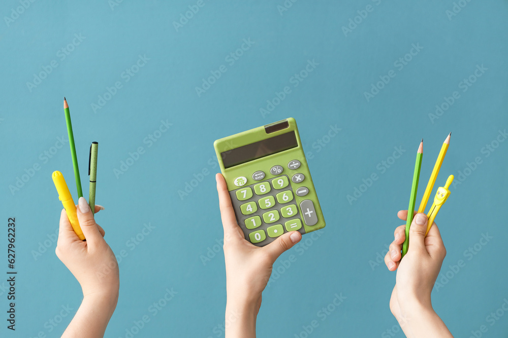 Female hands with school supplies on blue background