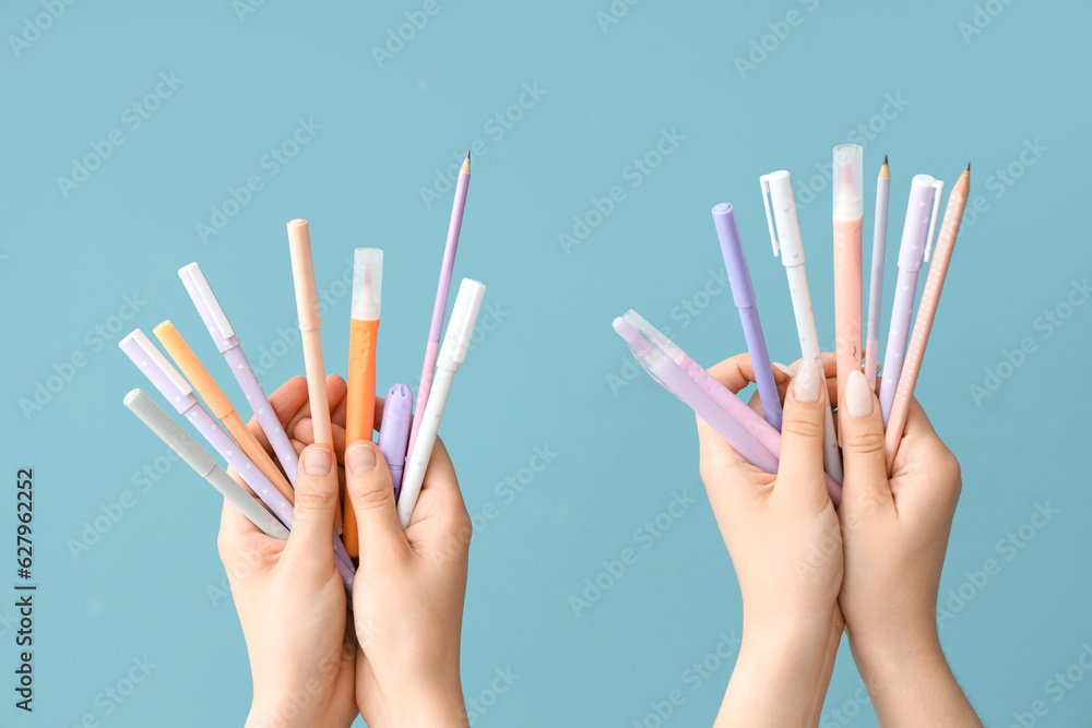 Female hands with school supplies on blue background