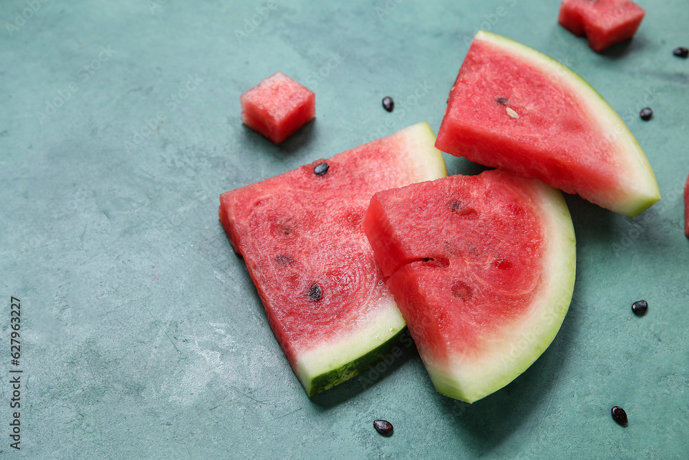 Composition with pieces of ripe watermelon on green background, closeup