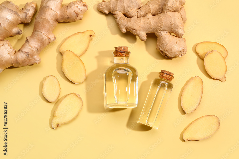 Bottles of ginger cosmetic oil on yellow background