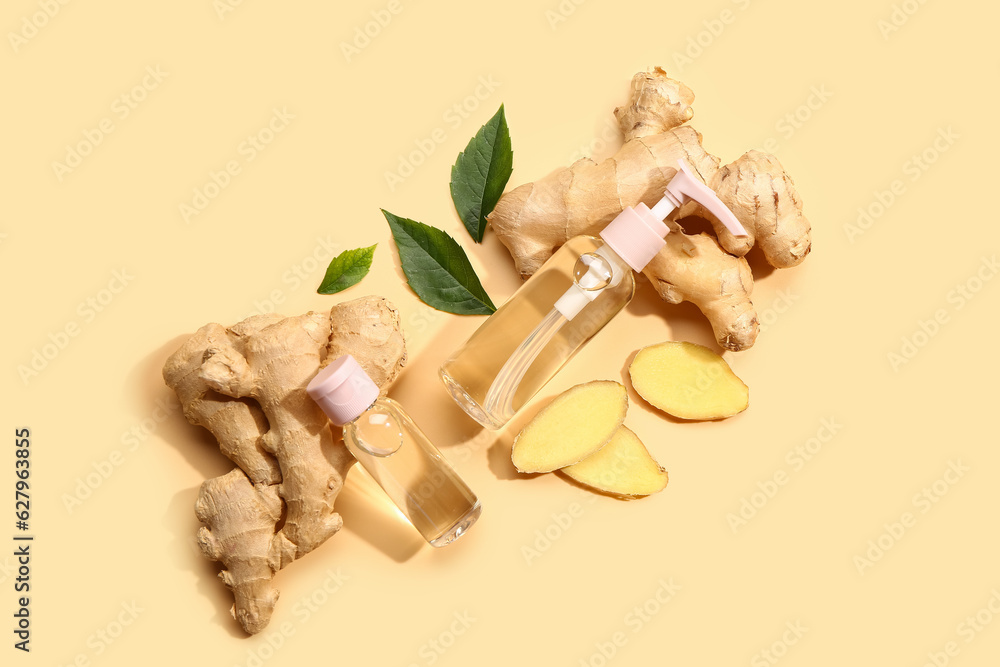 Bottles of ginger cosmetic oil and leaves on yellow background