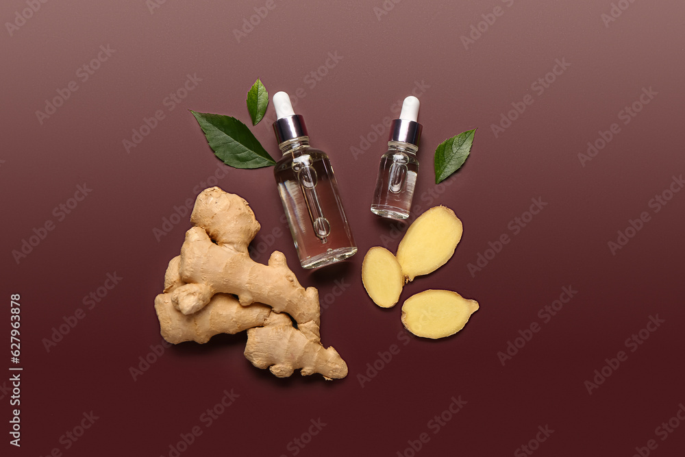 Bottles of ginger cosmetic oil and leaves on brown background