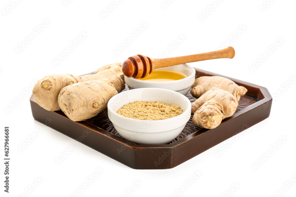 Tray with fresh ginger roots and bowl of dried powder on white background