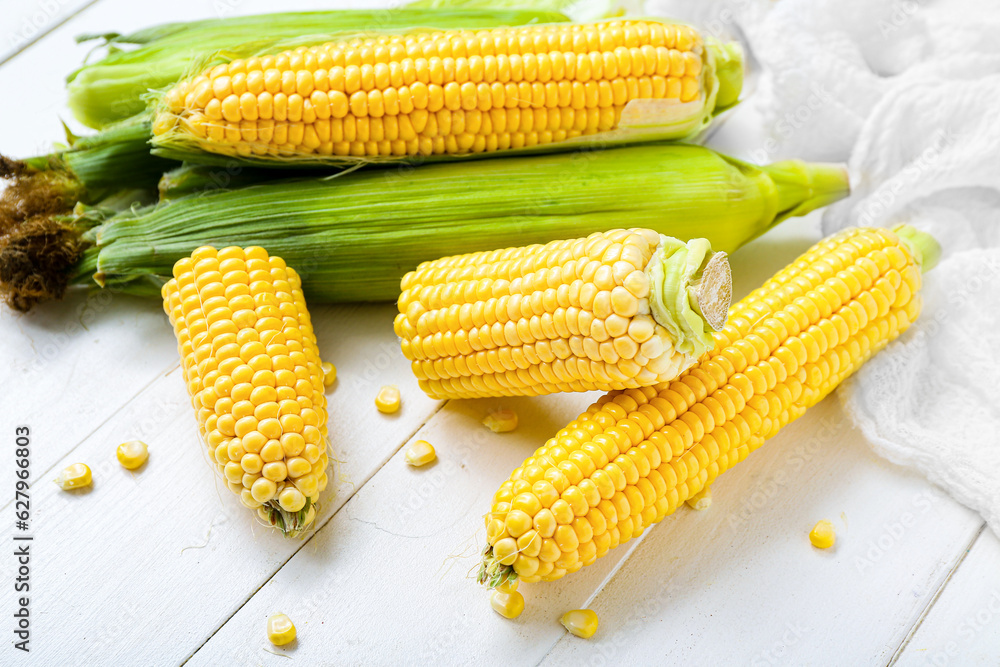 Fresh corn cobs on white table