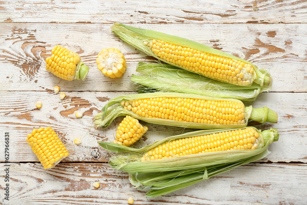 Fresh corn cobs on weathered wooden table