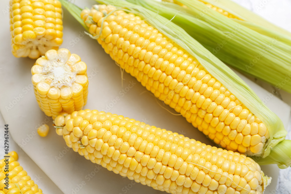 Board with fresh corn cobs, closeup