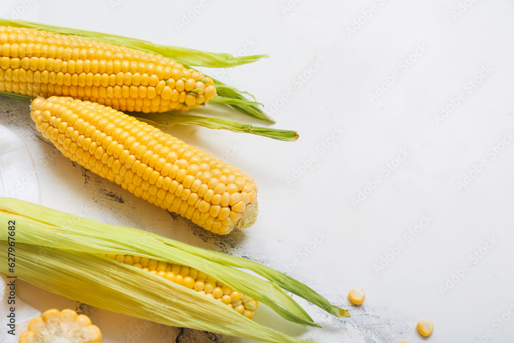 Fresh corn cobs on white marble table