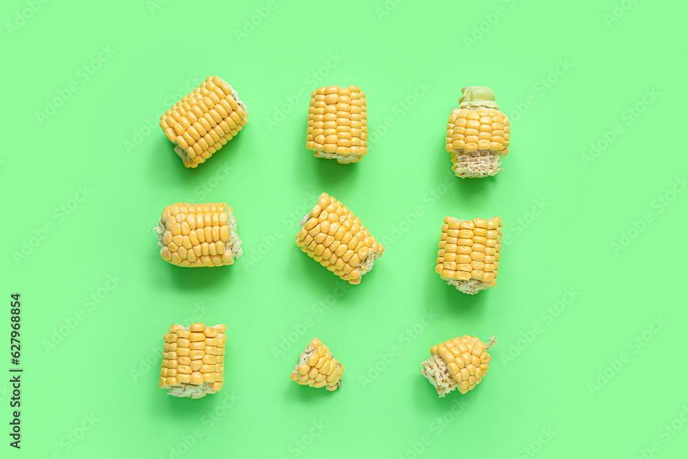 Composition with cut corn cob on green background