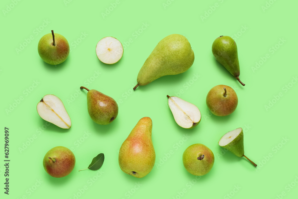 Different types of ripe pears on green background