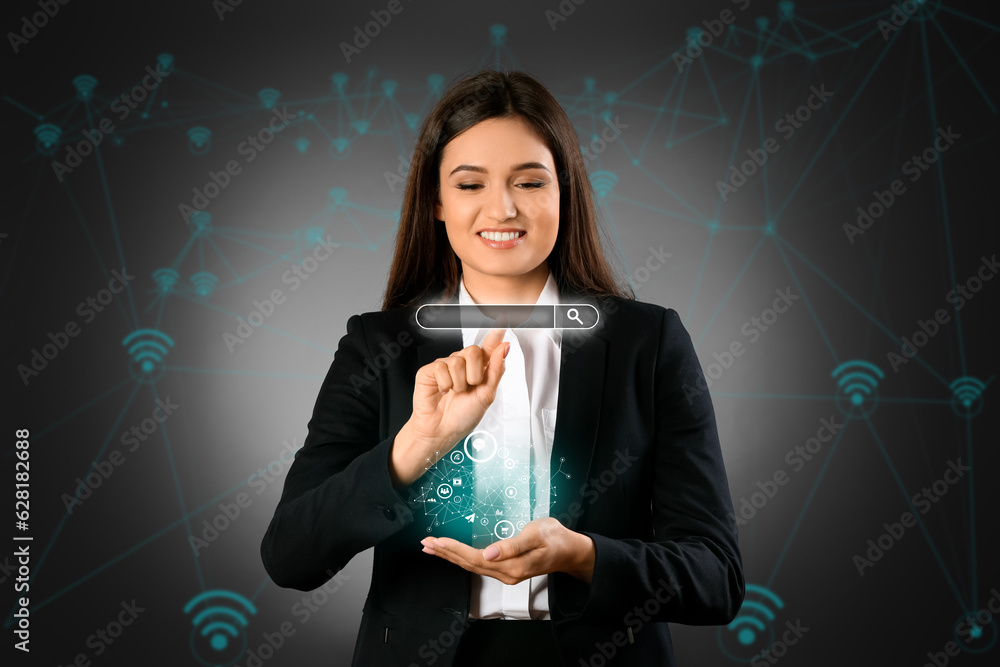 Young businesswoman with virtual screen using web search engine on dark background