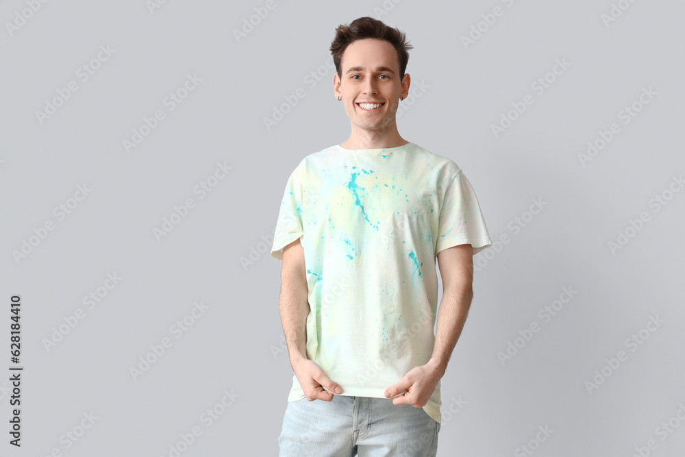 Young man in tie-dye t-shirt on light background