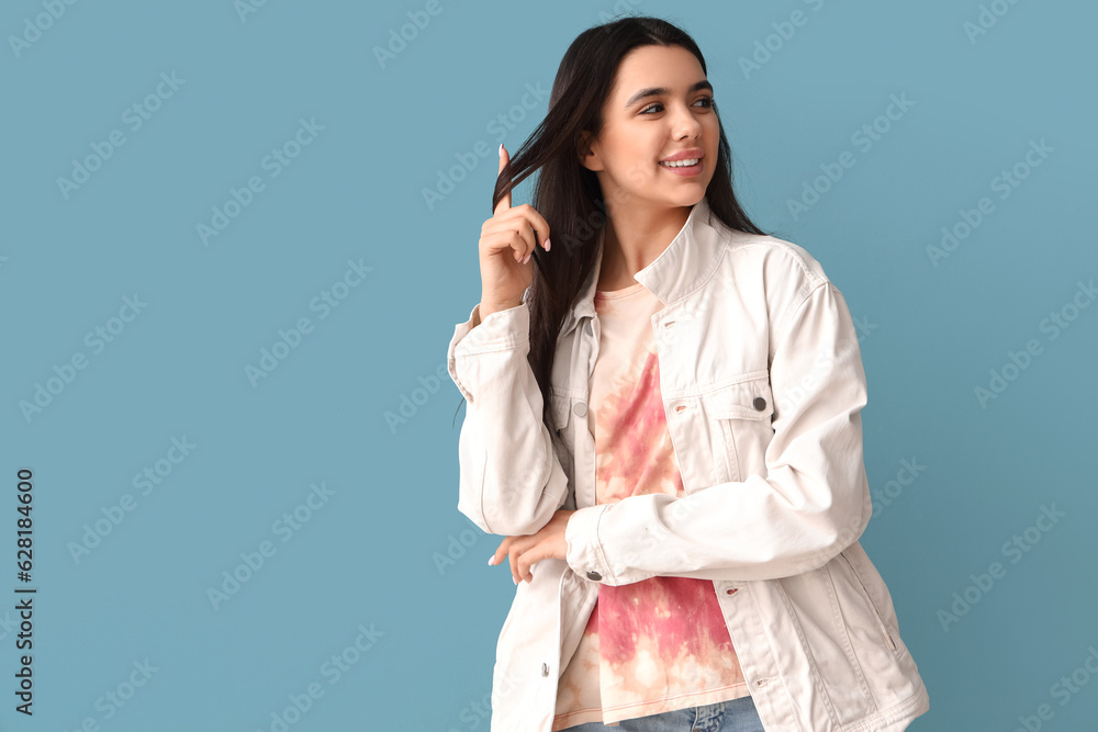 Young woman in tie-dye t-shirt on blue background