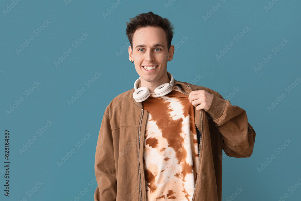 Young man in tie-dye t-shirt on blue background