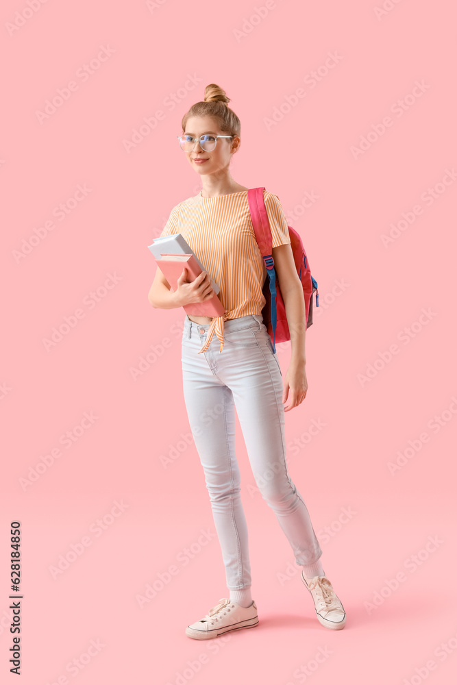 Female student with books and backpack on pink background