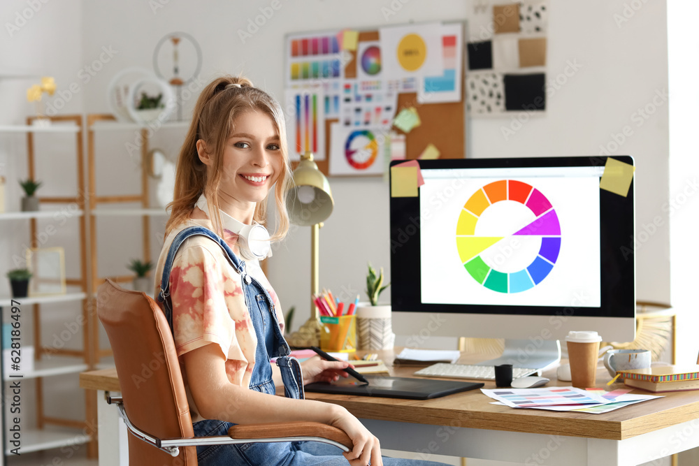 Female graphic designer working with tablet at table in office