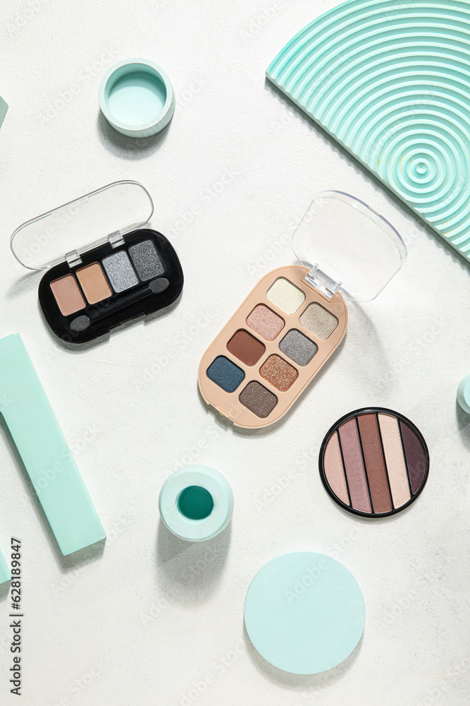 Palettes of eyeshadows with podiums on white background