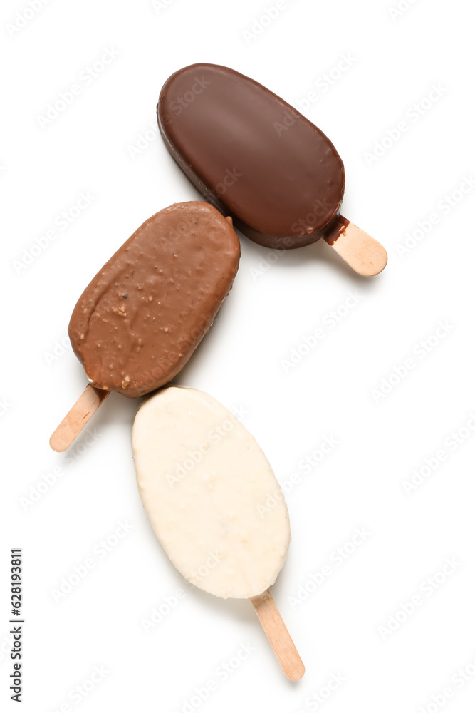 Different chocolate covered ice cream on stick against white background