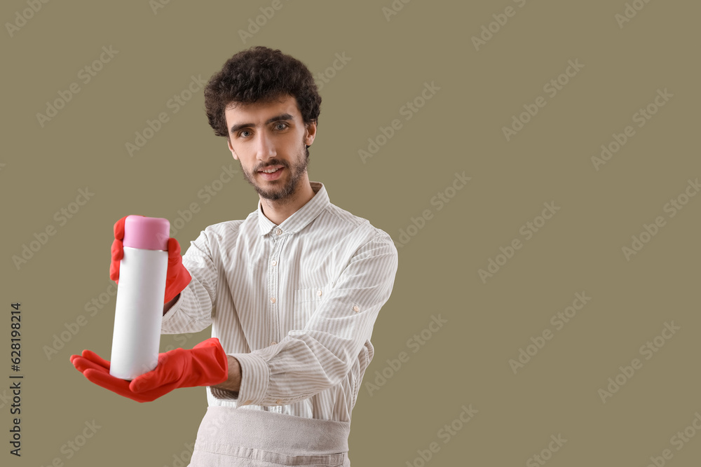 Young man with air freshener on green background